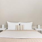 Bedroom with bed, two nightstands, and pillows under sloped walls.