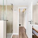 Bathroom with shower, sink, and view into the hallway.