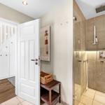 Hallway with shower and stairs to upper floor.