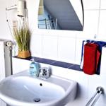 Badezimmer mit Waschbecken, Spiegel und Handtuchhalter