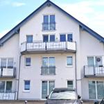 Außenansicht vom Haus mit Parkplätzen