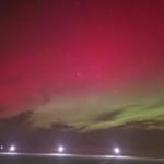 Nachtansicht mit leuchtendem Himmel und Straßenlaternen im Vordergrund.