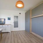 Living and dining area with TV, cabinets, and wooden floor.