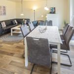 Esszimmer mit Tisch und Stühlen, Wohnbereich mit Sofa und Couchtisch