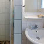Badezimmer mit Dusche, Waschbecken und Spiegel