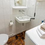 Badezimmer mit Toilette, Waschbecken und Wäschetrockner mit Handtüchern.