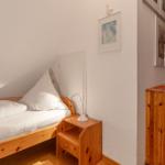 Ein Schlafzimmer mit einem Bett, Nachttisch und Schrank aus Holz.