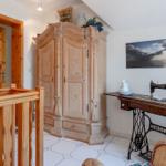 Holzgetäfeltes Schlafzimmer mit Schrank, Nähmaschine und Wandbild.