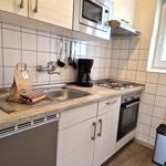 Küche mit Spüle, Herd, Mikrowelle und Fenster