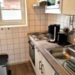 Küche mit Kochfeld, Spüle, Mikrowelle und Kaffeemaschine.