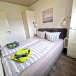 Schlafzimmer mit Doppelbett, Wandlampen und Bild an der Wand.