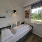 Schlafzimmer mit Bett, Fenster und Wandbild.