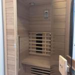 Sauna mit Holzwand, Sitzbank und Steuerung