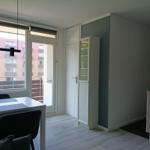 Essbereich mit Tisch, Stühlen und Blick auf Balkon. Küchenzeile und Schrank sichtbar.