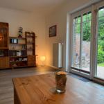 Ein Raum mit Holzmöbeln, Glasfront und Blick auf einen Garten.