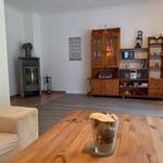 Wohnzimmer mit Holzmöbeln, Kamin und Tisch mit Schale