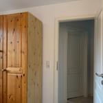 Holzschrank mit Spiegeltür, Türöffnung und Steckdose an Wand