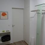 Flur mit Garderobe, Wandbild und kleinem Regal mit Tasche.