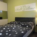 Schlafzimmer mit Bett, Wandbild und Nachttisch
