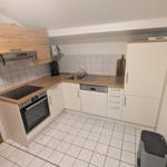 Küche mit Holz Arbeitsplatten, Spüle, Herd und Kühlschrank.