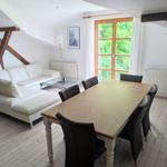 Wohn- und Essbereich mit Sofa, Esstisch und Fenster zum Balkon.