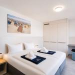 Bedroom with double bed, wardrobe, and wall art featuring a beach scene.