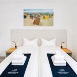 Room with double bed, wall picture, and towels on bed.