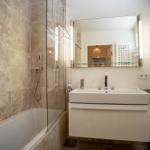 Bad mit Dusche, Badewanne und Waschbecken mit Spiegel