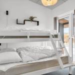 Ein Schlafzimmer mit einem Doppelstockbett und einer Glastür zum Balkon.