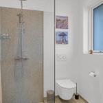 Badezimmer mit Dusche, Toilette und Fenster