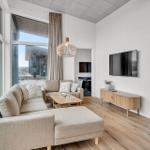 Wohnzimmer mit Sofa, Fernseher und großem Fensterblick.