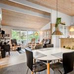 Essbereich mit runden Tisch und Stühlen. Küche und Wohnzimmer im Hintergrund.