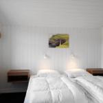 Schlafzimmer mit Doppelbett, zwei Nachttischen und Wandbild. Decke und Wände sind weiß verputzt.