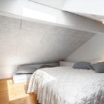 Schlafzimmer mit Dachschrägen, Bett und Sitzgelegenheit