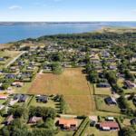 Luftbild von Ferienhäusern am Meer mit Grünflächen und Straßen.