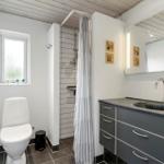 Badezimmer mit Toilette, Dusche und Waschbecken mit Spiegel.