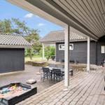 Terrasse mit Grill, Tisch und Stühlen. Sandkasten und Gartenhaus sind vorhanden.