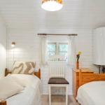 Zimmer mit zwei Betten, Fenster, Stuhl und Heizung.