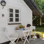 Wohnung mit weißen Wänden, Fenster und Tisch mit Stühlen auf der Terrasse.