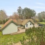 Ein Haus mit Terrasse, Garten und Boot auf dem Grundstück.