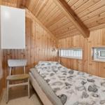 Ein Schlafzimmer mit Holzwänden, einem Bett und einem Stuhl.