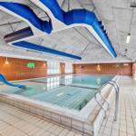 Innenpool mit blauer Rutsche und Kinderwandmalereien an Backsteinwänden.