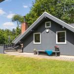 Ein graues Holzhaus mit Schornstein, Fenstern und einer Bank im Garten.