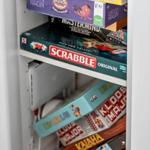 Schrank mit Brettspielen wie Scrabble und Mastermind.