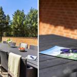 Terrasse mit Tisch, Stühlen und Blick auf Wald. Sonnenbrille und Broschüre auf Tisch.