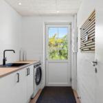 Wohnung mit Waschmaschine, Spüle und Tür zum Garten.