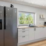 Moderne Küche mit Kühlschrank, Arbeitsplatte und Fenster.
