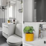 Badezimmer mit Badewanne, Waschbecken und Toilette. Gelbe Pflanze und Seife auf dem Waschtisch.