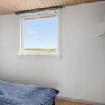Schlafzimmer mit Bett, Fenster und Kleiderschrank. Blick auf Feld.