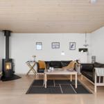 Wohnzimmer mit Kamin, Sofa, Tisch und Fernseher.